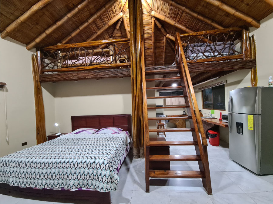 bedroom and kitchen with wooden steps in the center